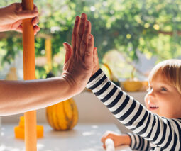 Child giving adult a high five - feature
