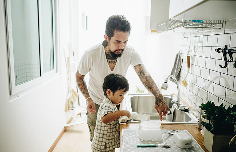 Father washing up with young son - feature