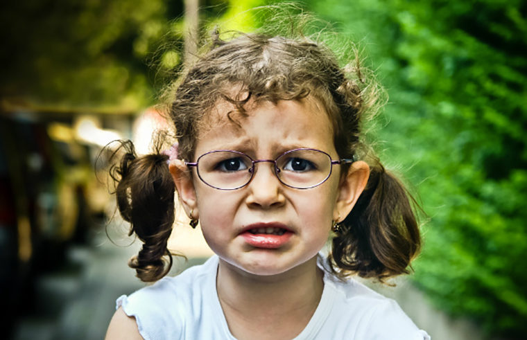 Young girl wearing glasses looking worried- feature