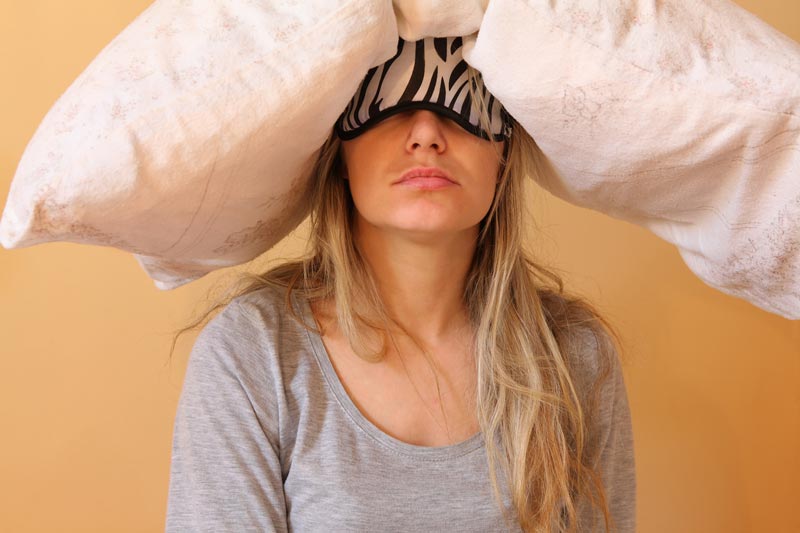 Tired mum with pillow on head