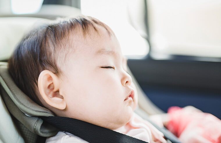Young baby asleep in car seat - feature