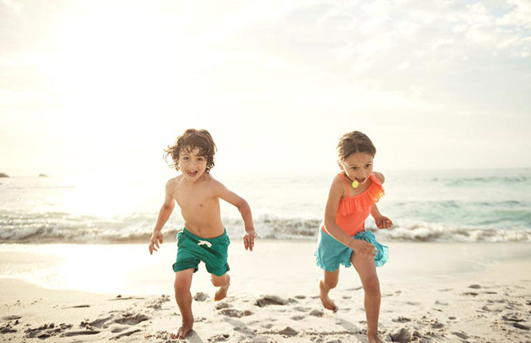girl and boy running on beach - feature