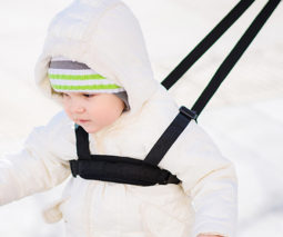 Toddler in winter clothes with child harness