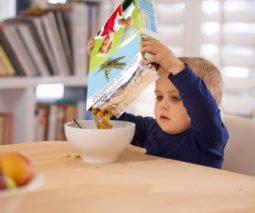 Toddler pouring his own cereal into a bowl