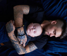 Father asleep with baby on his chest - feature