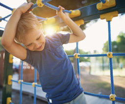 Young boy playing at playground - feature