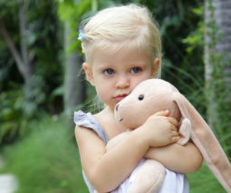 Blonde toddler girl holding toy bunny