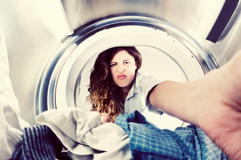 Annoyed woman looking in washing machine