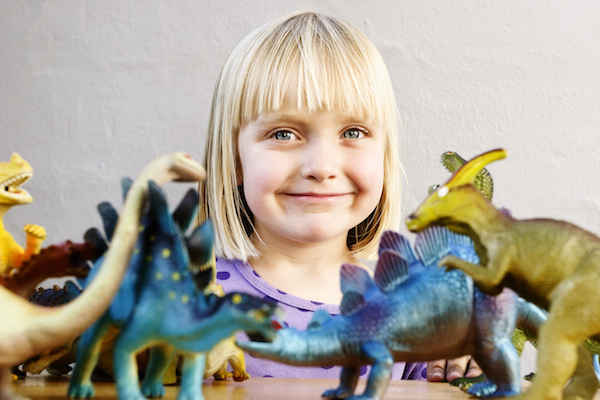 Little girl with toy dinosaurs