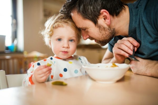 Toddler eating with dad
