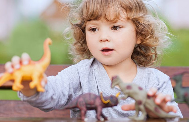 Toddler boy playing with dinosaurs - feature