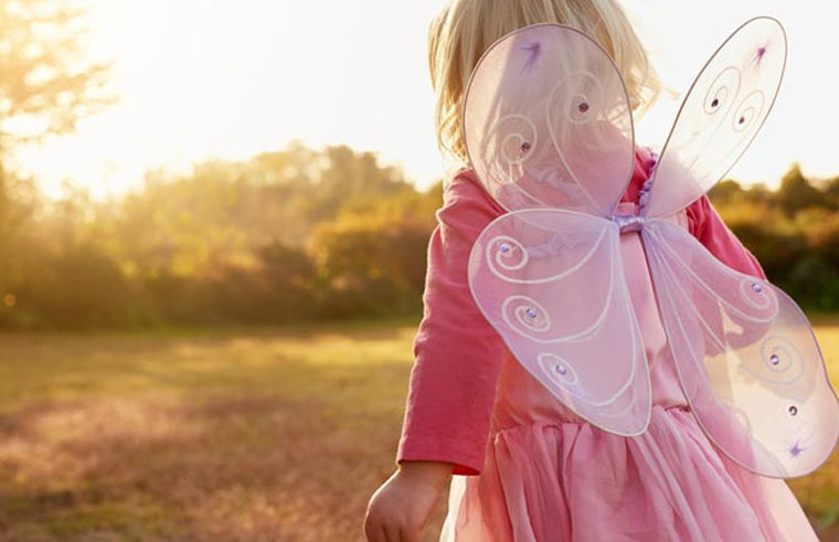 Toddler girl outdoors wearing pink fairy wings costume