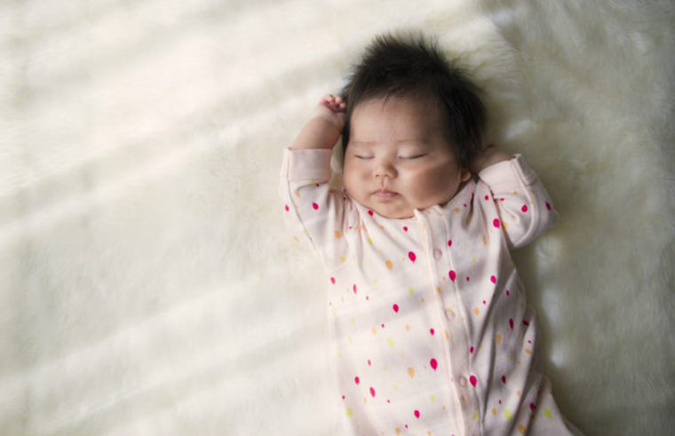 Asian baby in onesie sleeping - feature