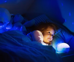 Toddler girl in bed with night light - feature