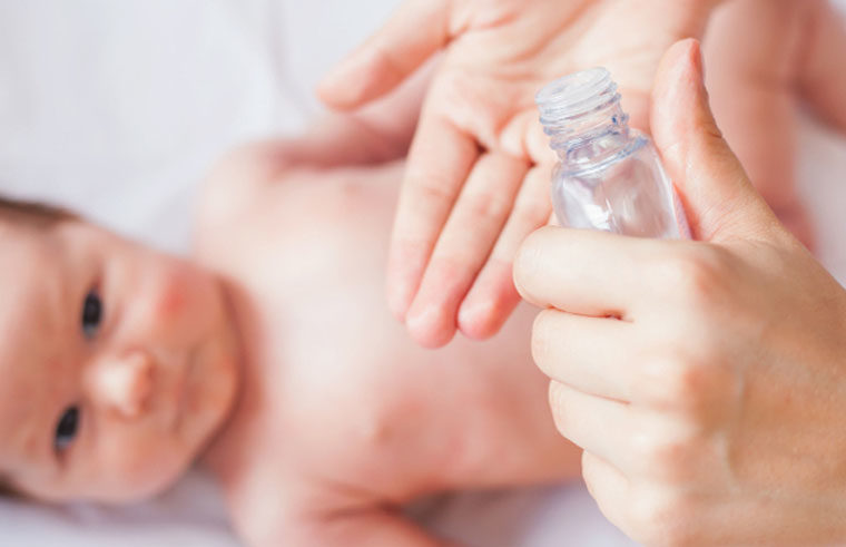 Pouring essential oil into hands, ready to massage baby
