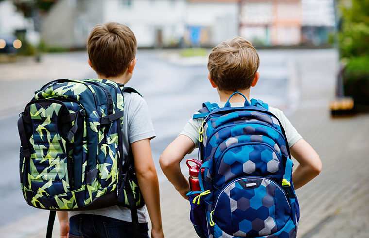 Twin boys going to school with school bags