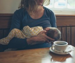 Mother breastfeeding and drinking coffee