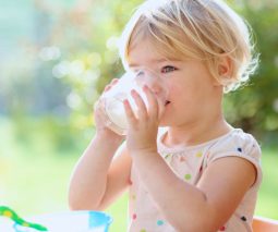 Toddler girl drinking a glass of milk
