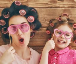 Mother and daughter pulling silly faces with hair in curlers and silly glasses