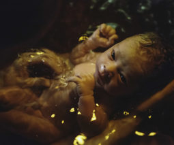newborn baby in birthing pool - feature