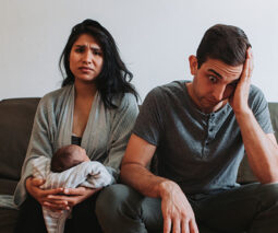Couple looking stressed with new baby - feature