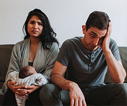 Couple looking stressed with new baby - thumbnail