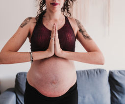 Pregnant woman doing yoga with stretch marks - feature