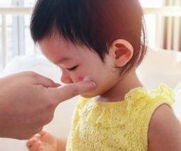 Toddler having cream applied to face