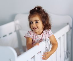 Toddler standing in cot