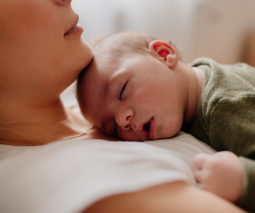Newborn baby sleeps on his mums chest