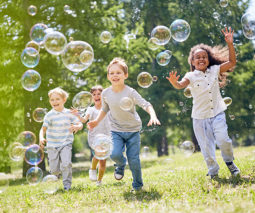 Children running with bubbles, happy and confident.