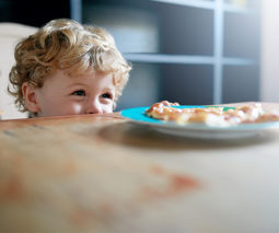 Toddler boy looking at dinner on kitchen table - feature