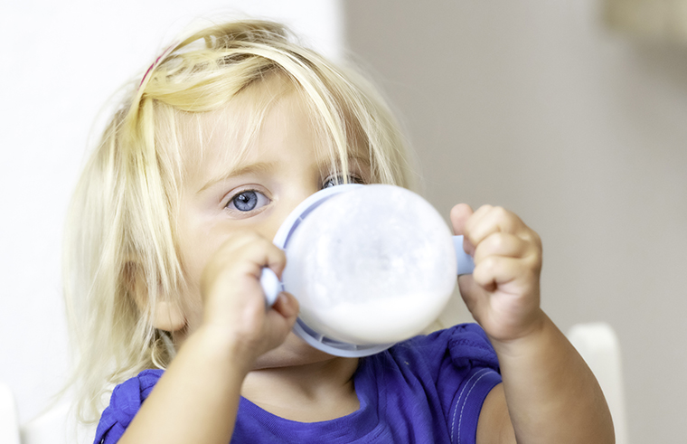 Toddler girl drinking milk from a bottle