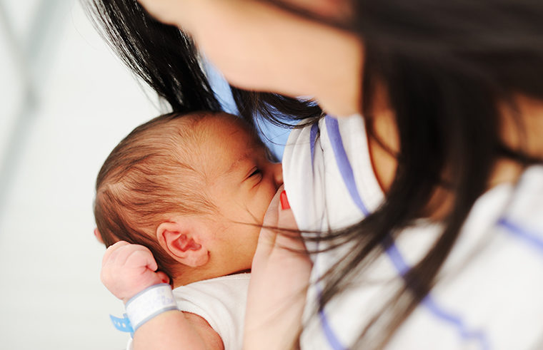 Asian mother breastfeeding newborn baby - feature