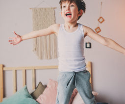 Preschool boy jumping on bed feature