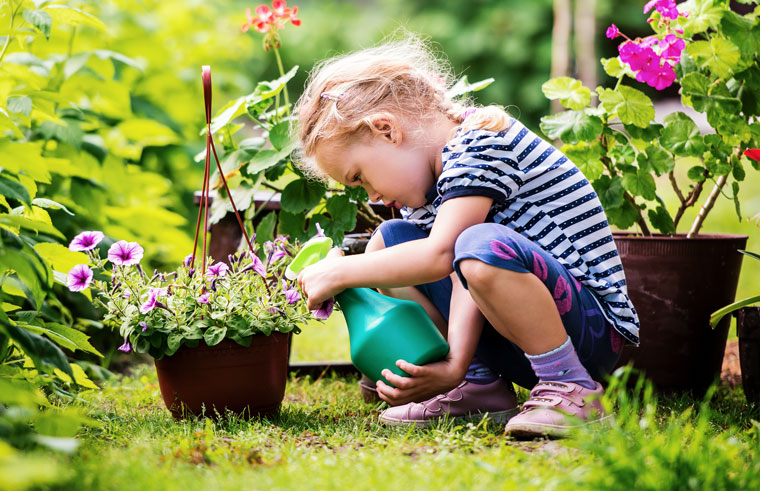 Little girl watering plants