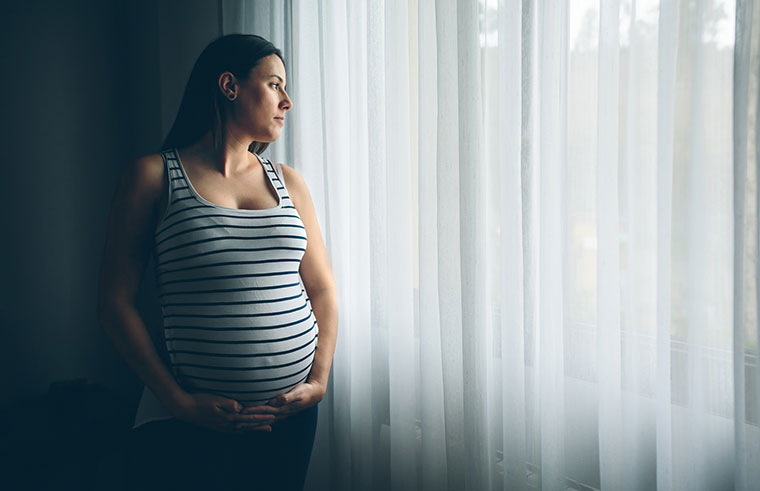 Pregnant woman, thinking and staring out window