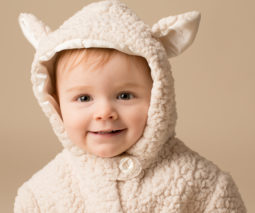 Cute toddler in a hooded sheep jacket