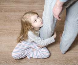 Child holding onto parents leg
