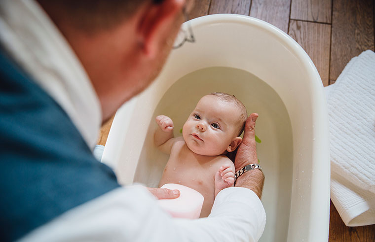 Dad giving baby a bath