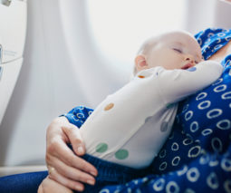 Baby asleep on mother on plane