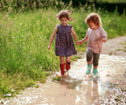 Girls wearing gumboots walking in puddle