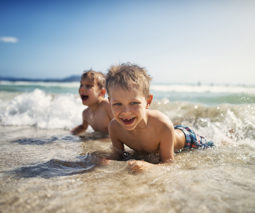Two boys at the beach in the water feature