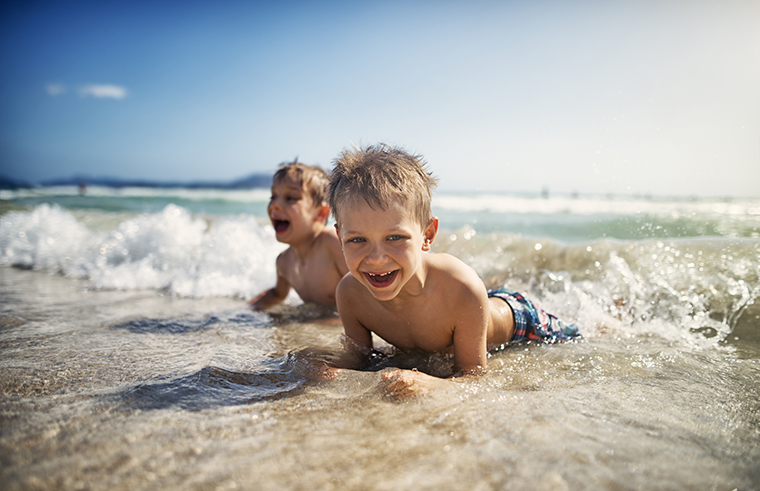 Two boys at the beach in the water feature