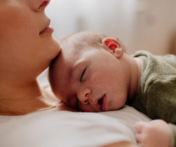 Newborn baby asleep on mum