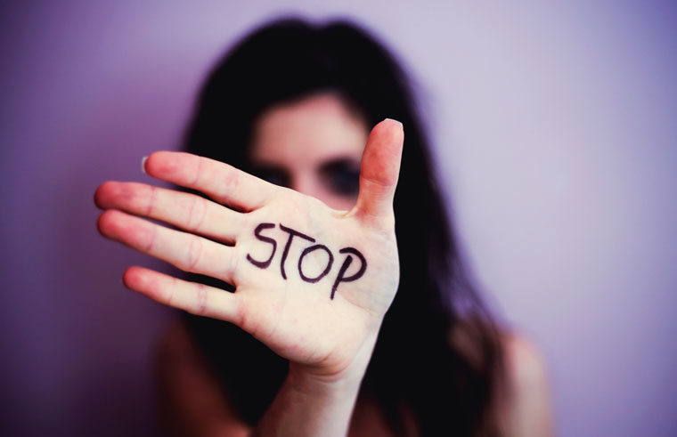 Woman with STOP written on hand