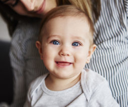 Baby blue eyes sitting in mother's lap feature
