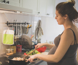 Pregnant woman cooking dinner at the stove