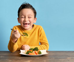 Happy boy eating veggies