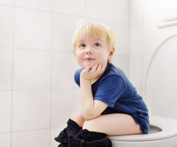 Young boy sitting on toilet